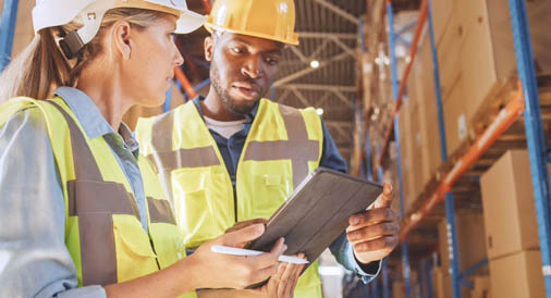 Two people in warehouse looking at tablet computer